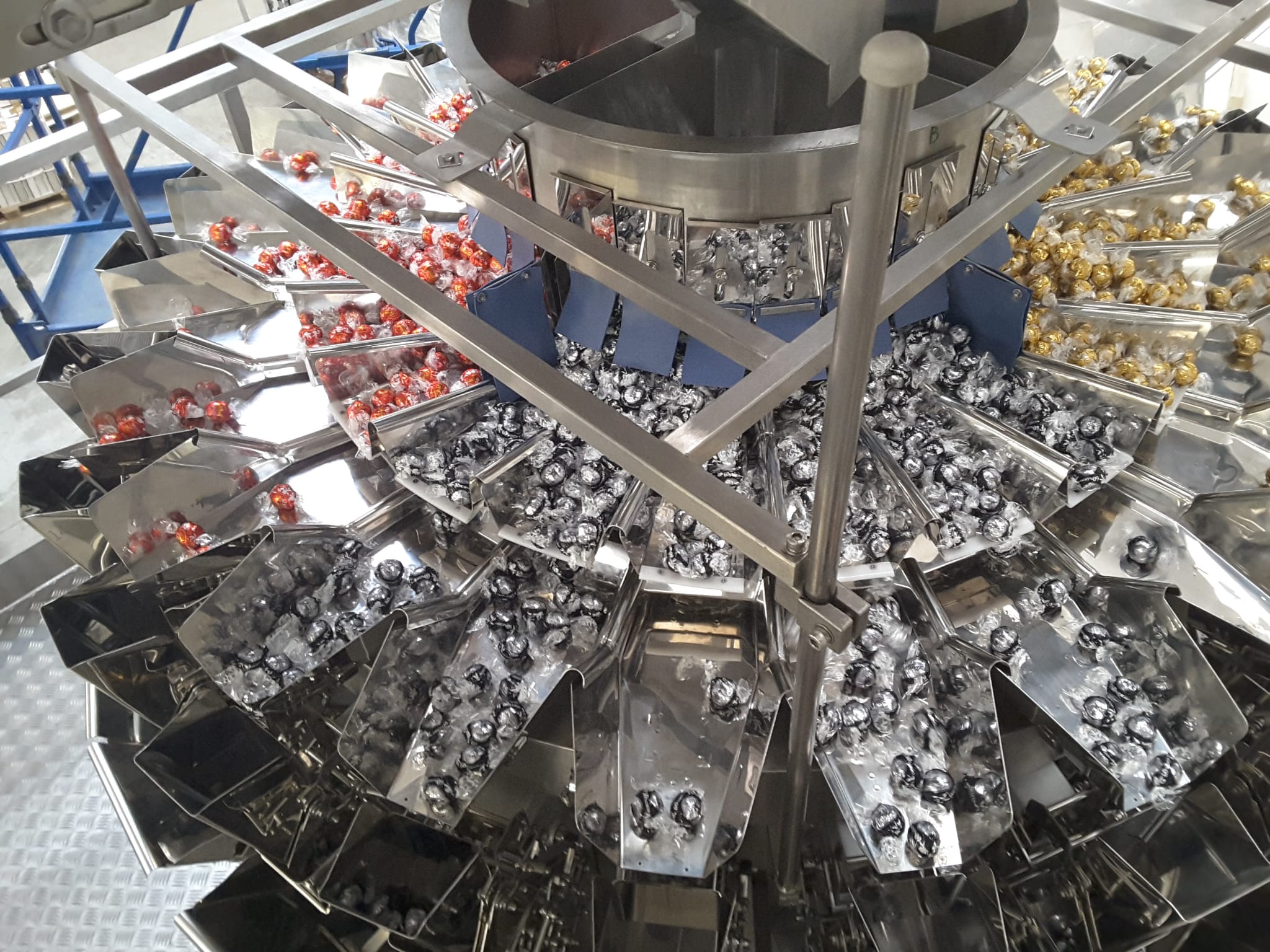 Multi-flavor multihead weighing system handling wrapped products for dosing and weighing